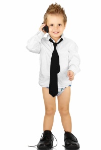 toddler with cell phone in white shirt, tie and large shoes